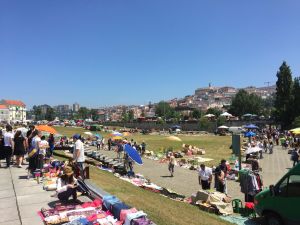 De universiteit boven het historische centrum, op de voorgrond de maandelijkse vlooienmarkt Maandmarkt Coimbra met universiteit op de achtergrond