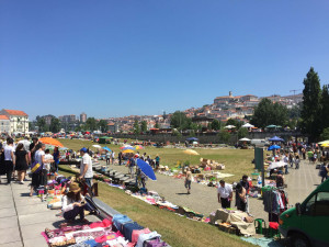 De universiteit boven het historische centrum, op de voorgrond de maandelijkse vlooienmarkt Maandmarkt Coimbra met universiteit op de achtergrond